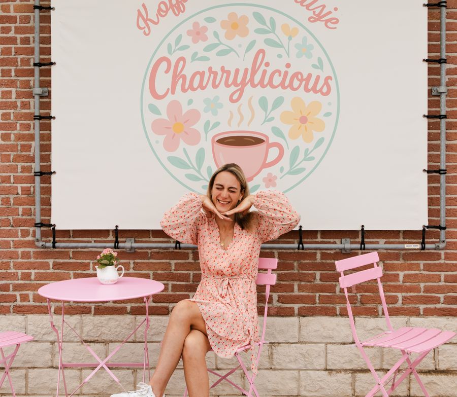 Charry lachend aan een roze tafeltje